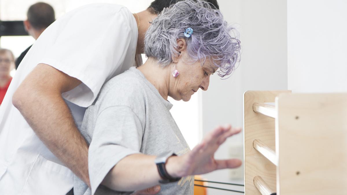 Una paciente de la Clínica de Nutrición, Actividad Física y Fisioterapia de la UV, junto al especialista.