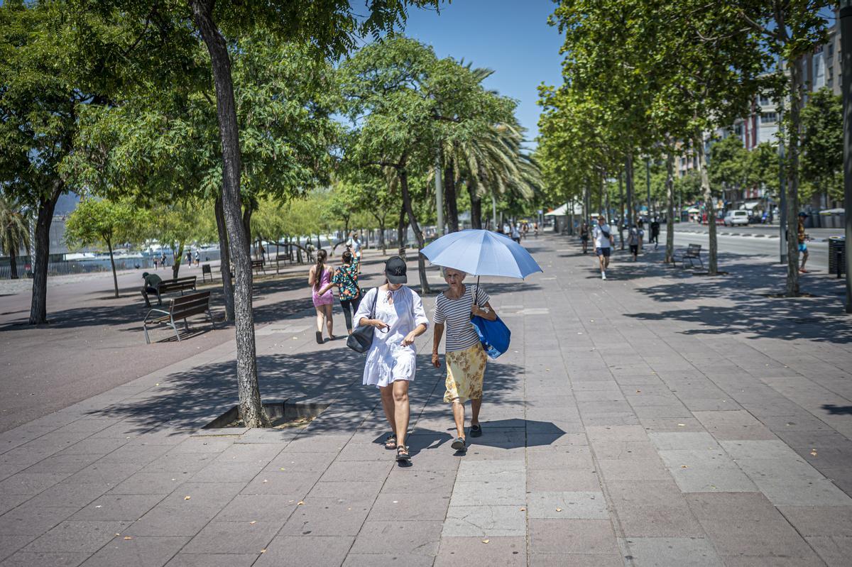 Ola de calor en Barcelona. Paseantes disfrutan de un poco de vapor de agua refrescante en un refugio climático instalado cerca de la Barceloneta, en el paseo de Joan de Borbó.
