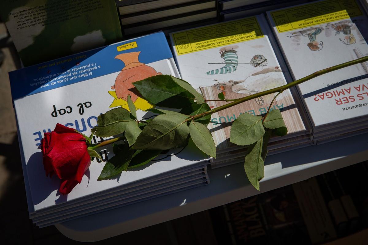 Una rosa sobre unos libros de una parada en el Día de Sant Jordi.