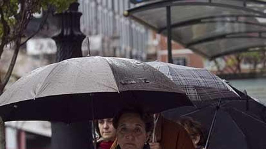 Una mujer, con paraguas, en Oviedo.