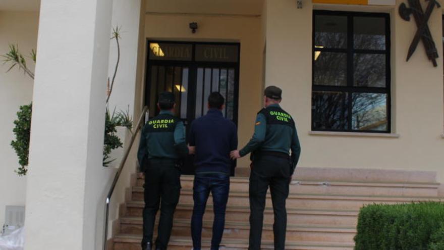 Uno de los dos detenidos, escoltado por dos guardias civiles