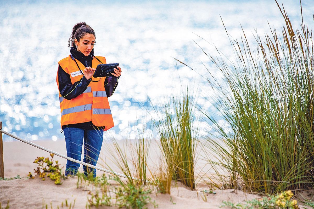 Una técnica del AMB comprueba las incidencias en la playa con una tableta