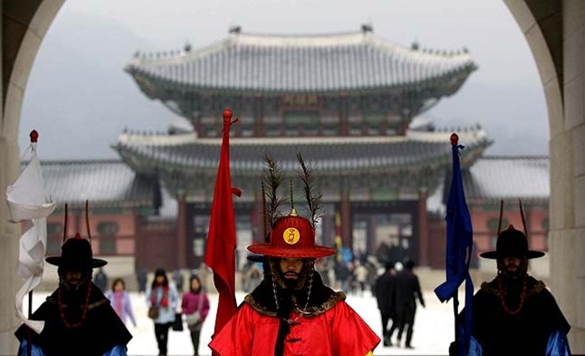 Tres homes sud-coreans vestits amb el vestit militar tradicional fan guàrdia al Palau Gyeongbok del segle XIV, un lloc turístic a Seül (Corea del Sud).