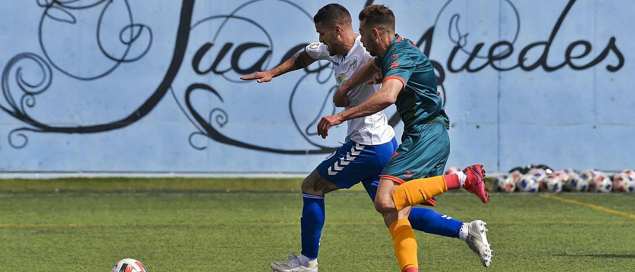 Eros, jugador de la UD Tamaraceite, perseguido por un futbolista del Algeciras en el campo Juan Guedes, el pasado domingo. | | ANDRÉS CRUZ