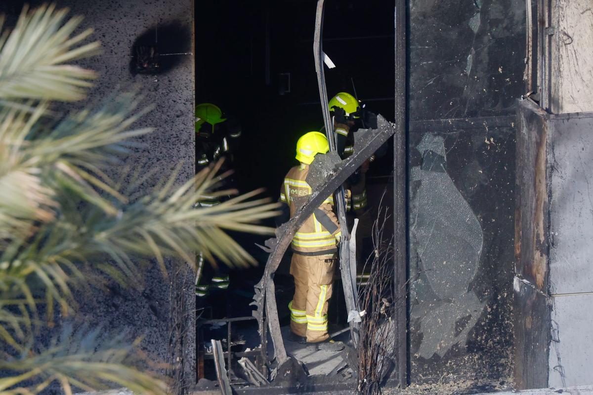 Bomberos inspeccionan en las viviendas calcinadas de Campanar.