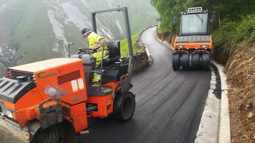 Los operarios municipales trabajan en el asfaltado de un vial en Allande.