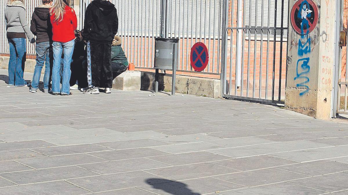 Jóvenes charlan en la puerta de un centro educativo.