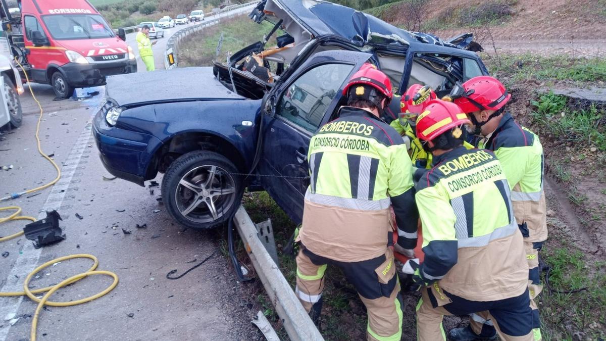 Los bomberos trabajan en el coche siniestrado.