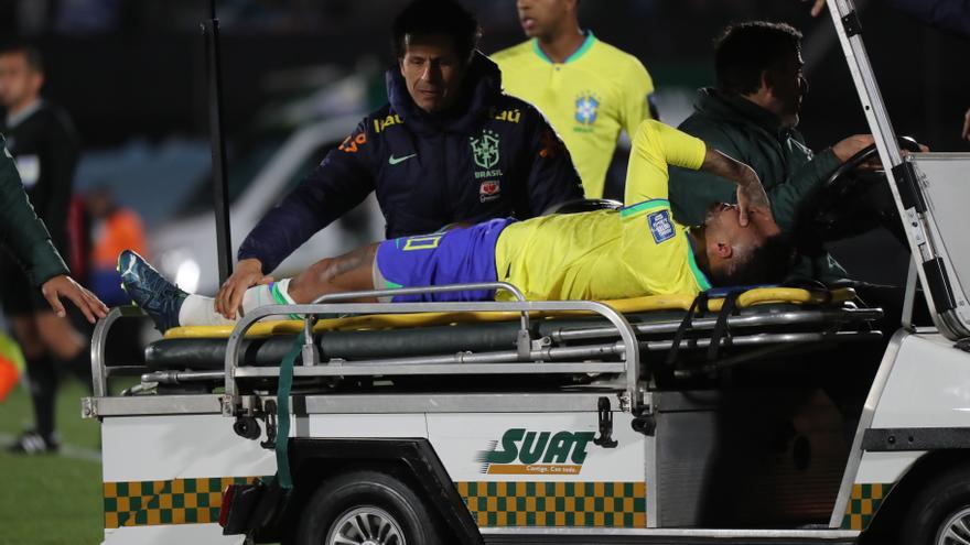 Neymar sale en camilla tras su lesión.