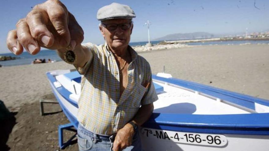 El marengo, junto a su chalana, sostiene una medalla de la Virgen del Carmen.