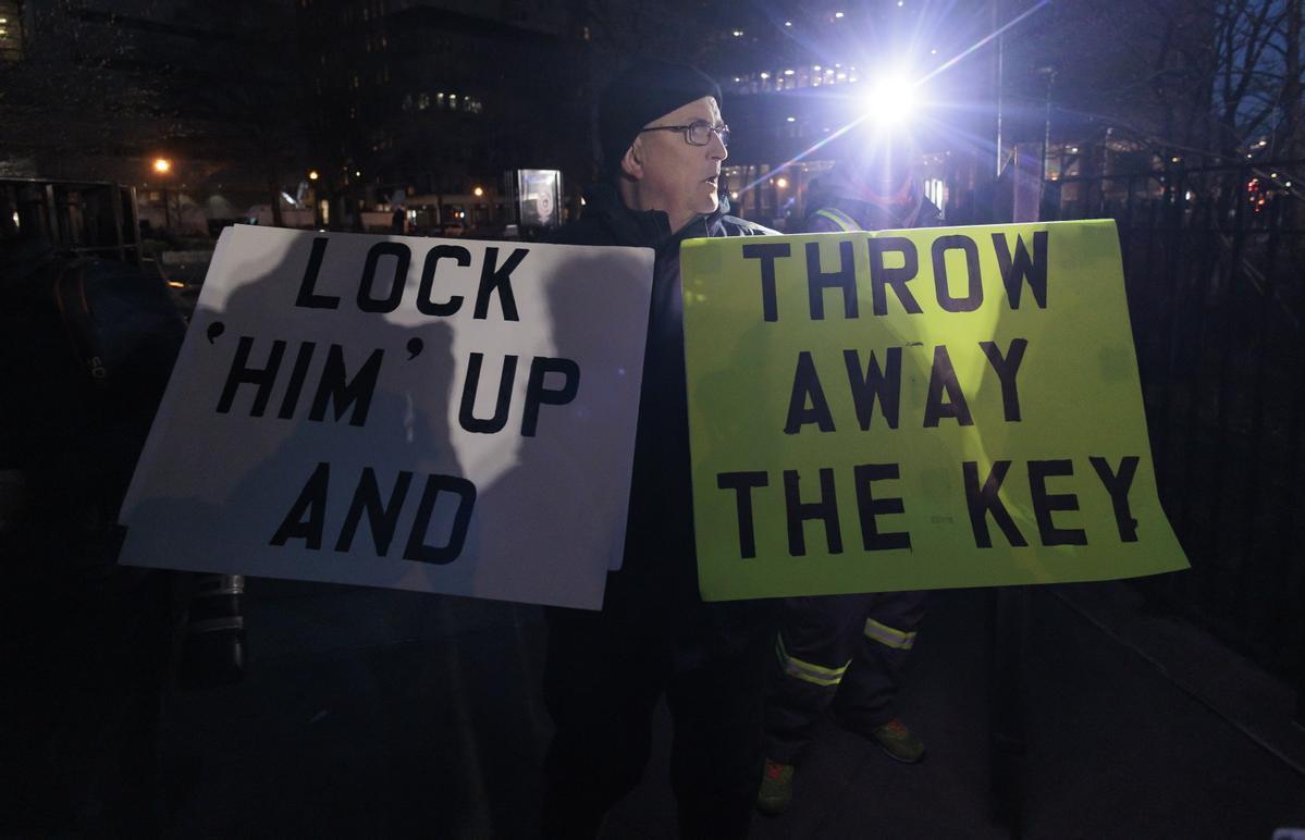  Una persona sostiene carteles frente al edificio del Tribunal Penal de Nueva York poco después de la acusación del expresidente Donald J. Tump en Nueva York.