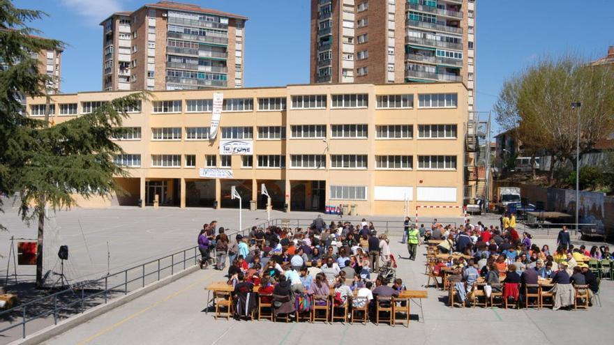 L&#039;escola La Font de Manresa amb dues de les característiques torres del barri al qual pertany de fons.