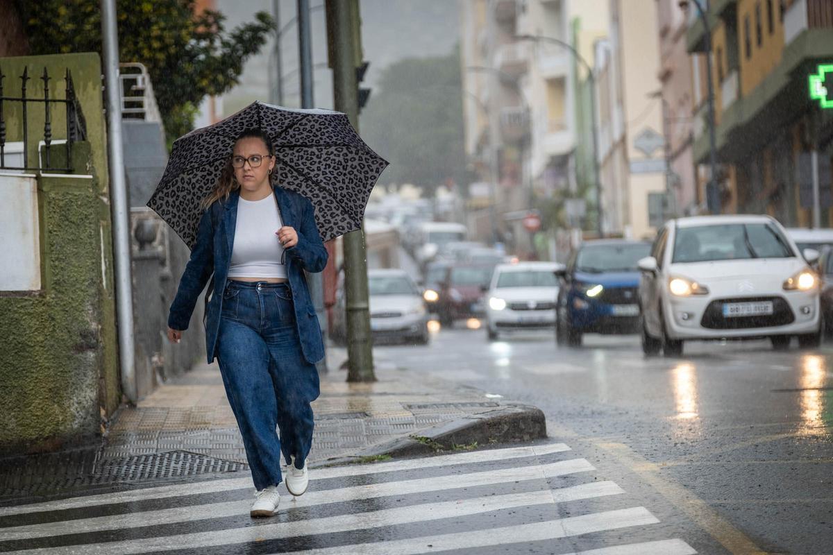 Una joven se protege de la lluvia con su paraguas.