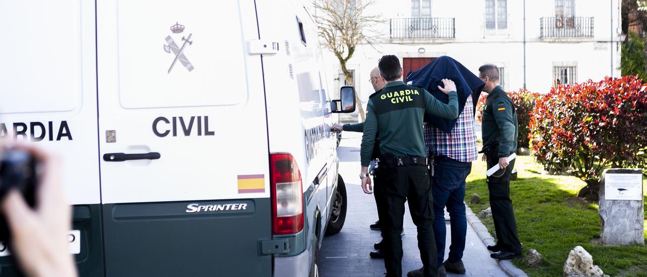 Uno de los procesados, a punto de entrar en un furgón de la Guardia Civil