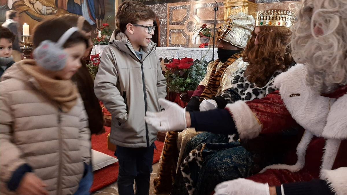 Los Reyes Magos llegan a Pola de Siero en descapotable y ofrecen una multitudinaria recepción a los niños en el templo parroquial