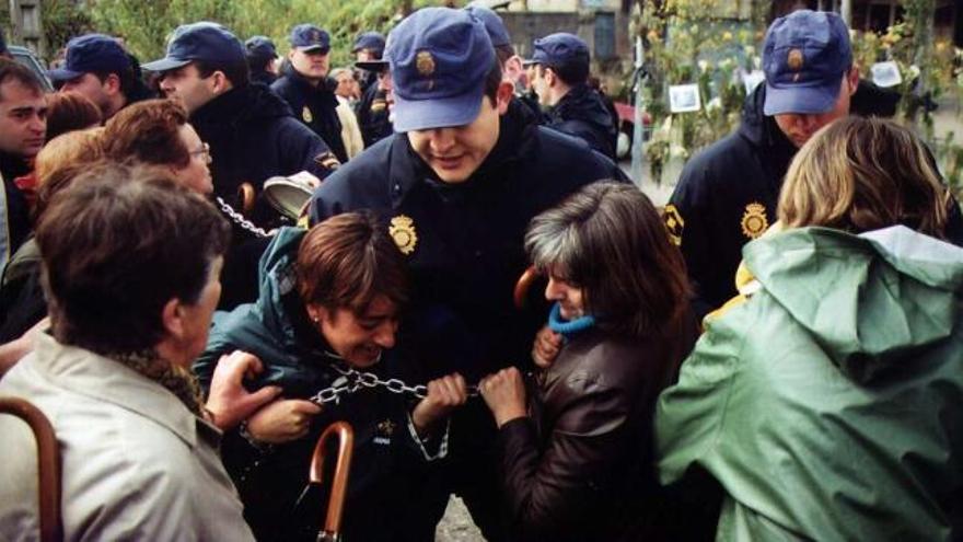 Un agente interviene en las protestas que se produjeron en 2001 para impedir el paso del tren por la plaza de Placeres.  // Rafa Vázquez