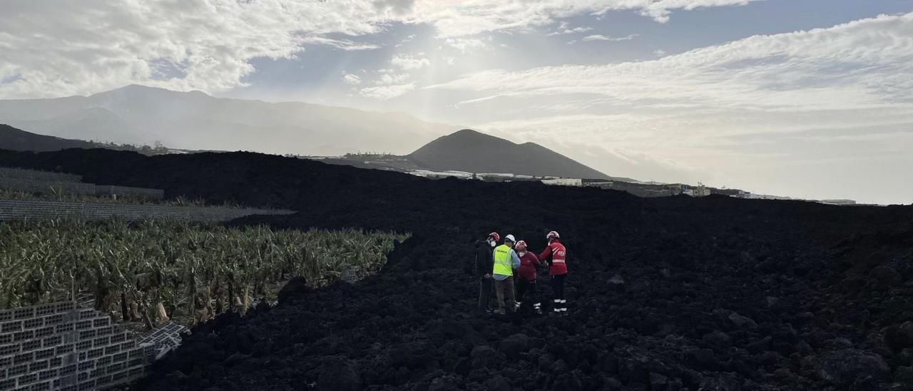 Un equipo del Instituto Geográfico Nacional (IGN) trabaja sobre una colada del volcán de Tajogaite.
