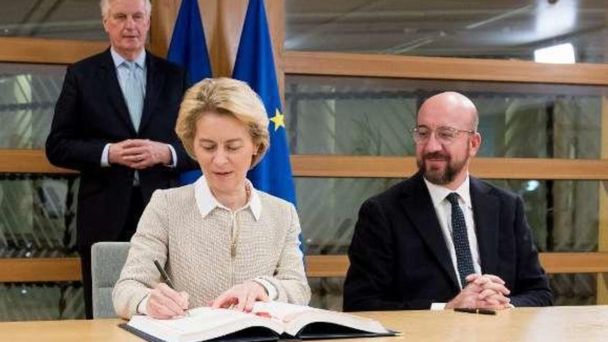 Von der Leyen firma el Acuerdo de Salida en presencia del presidente del Consejo, Henri Michel. al fondo, el negociador Barnier. // E.P.