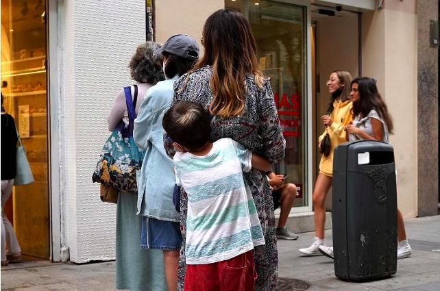 Un niño abraza a su madre, en una calle de Madrid