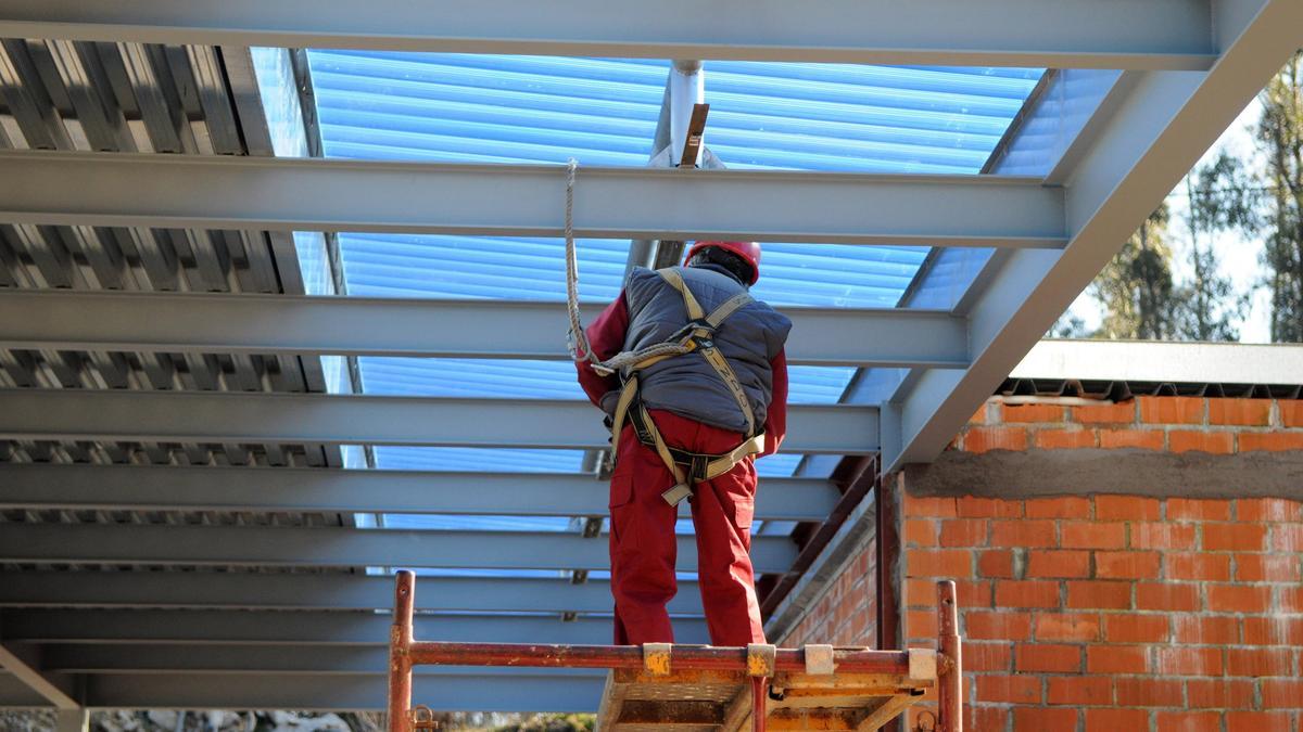 Un trabajador sobre un andamio con las medidas de protección adecuadas.