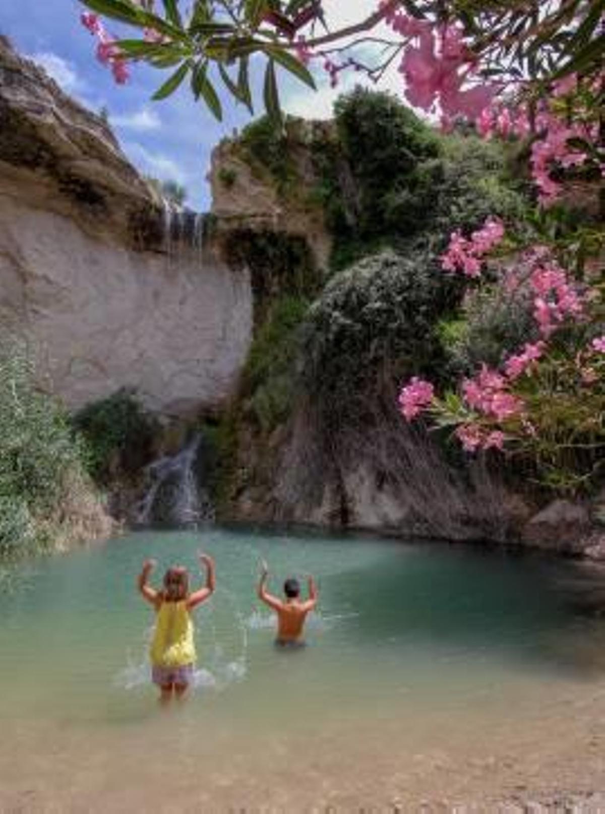 Dos niños bañándose ayer en la poza del Salt de Puça.
