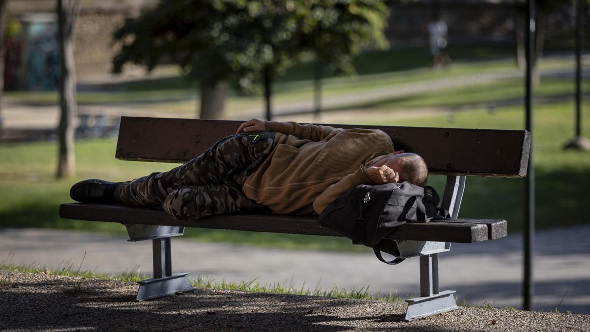 Una persona sin hogar duerme en el parque Bruil de Zaragoza.