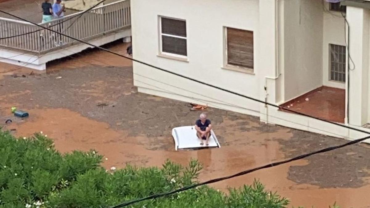 Un hombre subido en el techo de su coche.