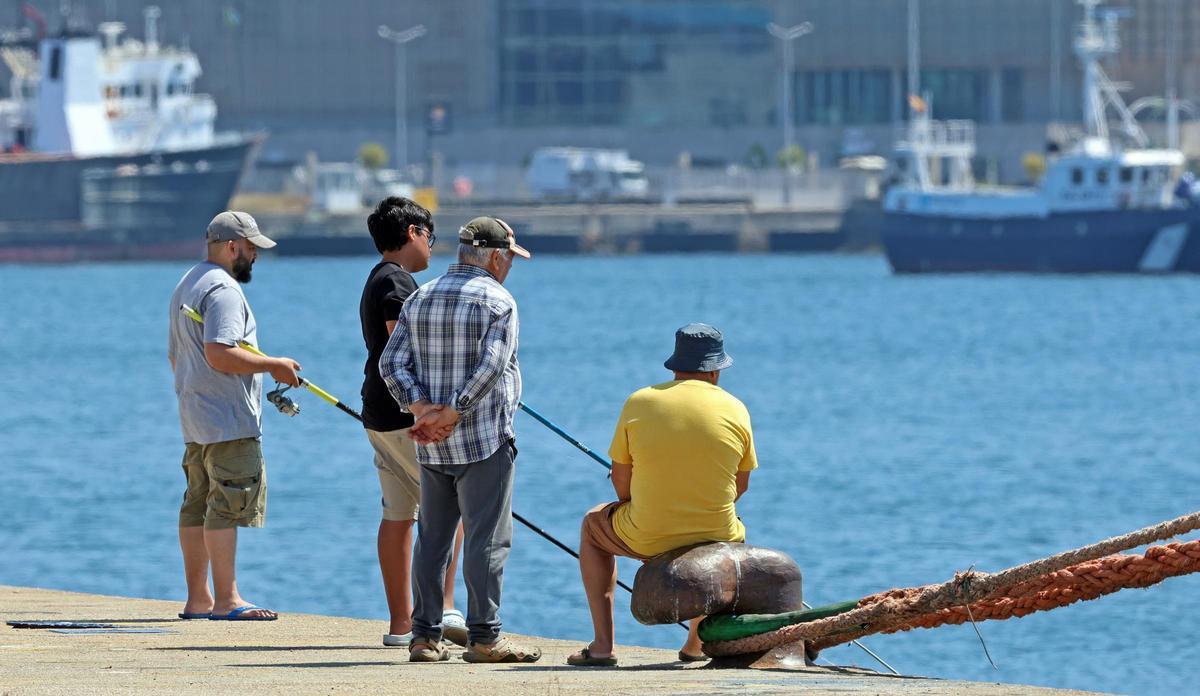 Pescadores aficionados en el muelle de reparaciones de Bouzas, en el puerto de Vigo.