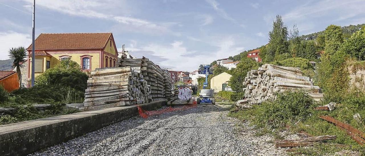 A ambos lados de la vía desmantelada en el antiguo apeadero de Chapela se acumulan vigas de cemento y traviesas de madera. // R. Grobas