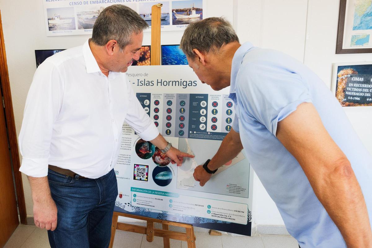 El consejero de Agua y Pesca, Joaquín Buendía, señala el mapa con la nueva zona de protección de la reserva marina.