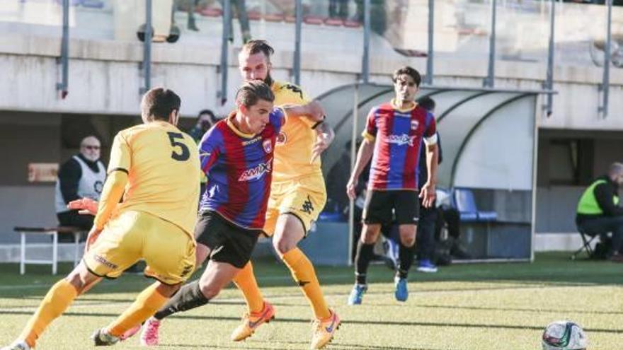 El delantero azulgrana Carlitos trata de zafarse de la férrea defensa del Reus Deportiu.