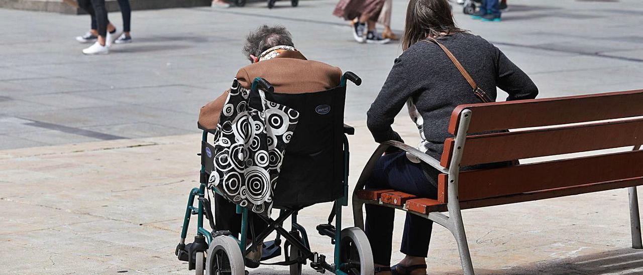 Una persona mayor, acompañada en un parque de Avilés. | Mara Villamuza