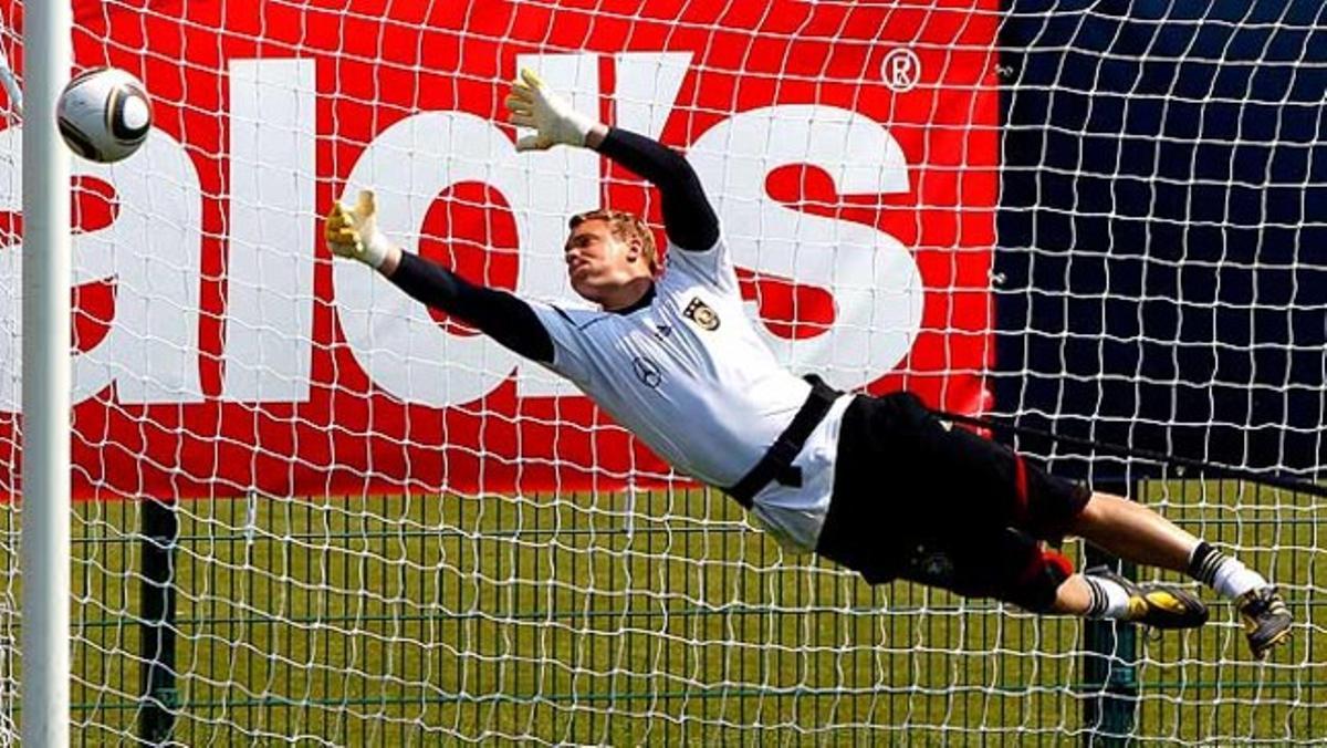 El porter de la selecció alemanya Manuel Neuer desvia la pilota durant les intenses sessions d’entrenament preparatòries per al campionat mundial de futbol.