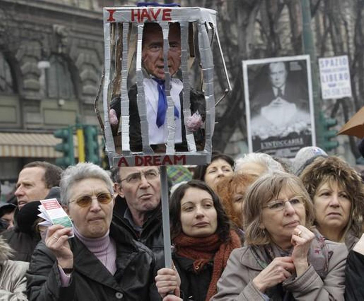 Un grup de dones mostren una gàbia amb un ninot que representa Berlusconi, durant una manifestació en protesta pels seus escàndols sexuals amb menors, el febrer del 2011 a Milà.