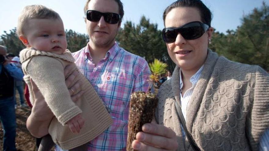 Rafael Cerezo y Patricia Suárez, con su hija Deva y el árbol que plantaron.