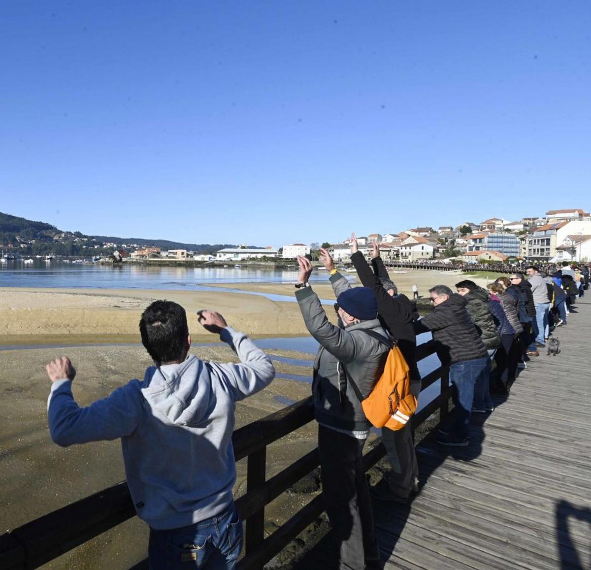 Asistentes a la movilización haciendo la ola en Aldán. |  P. H.