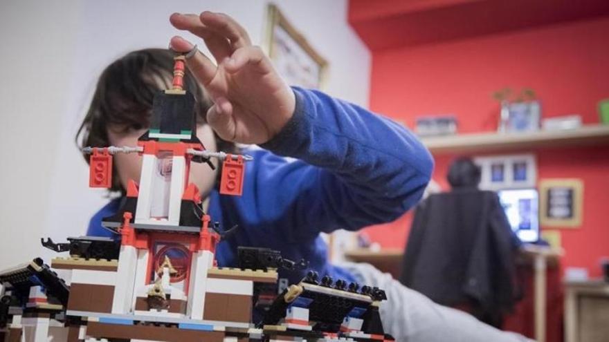 Un niño haciendo una construcción en el salón de su casa.