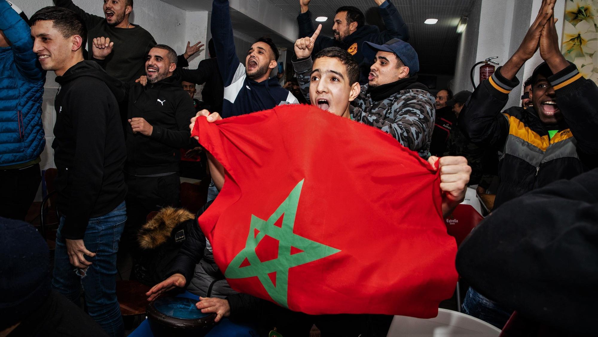 Aficionados de la selección de Marruecos celebran la victoria ante España en octavos del Mundial en un bar de L'Hospitalet de Llobregat.