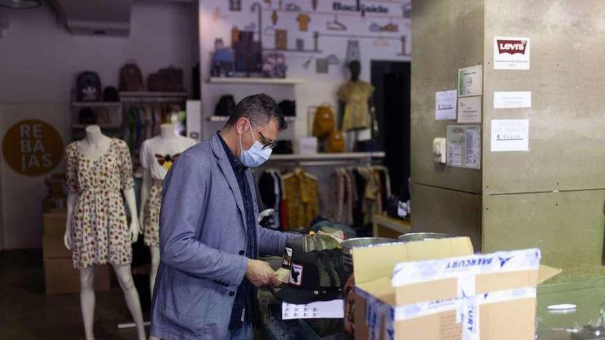 Oscar Barba coloca la ropa de temporada durante los preparativos para la reapertura.