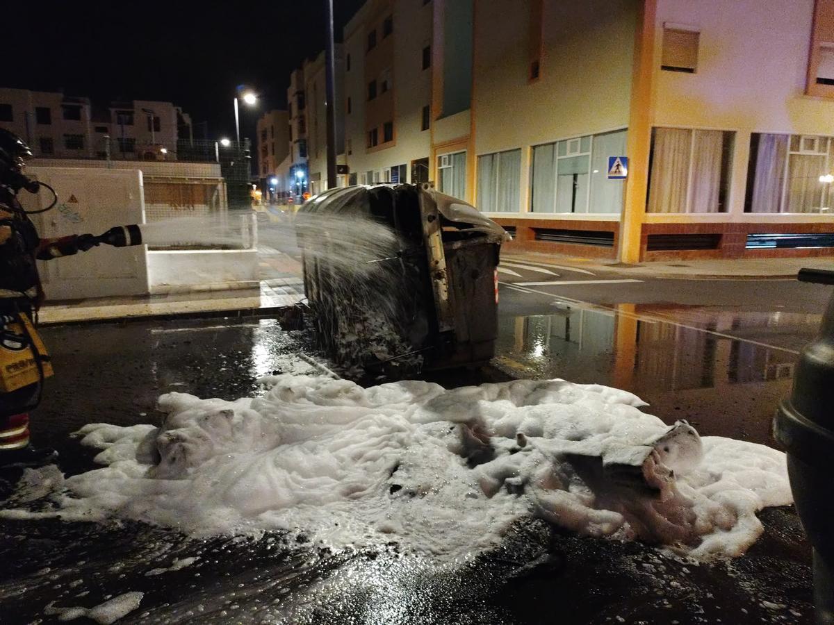 Un bombero apaga el fuego en un contenedor en la calle Yágabo, en Arrecife, en la madrugada de este martes