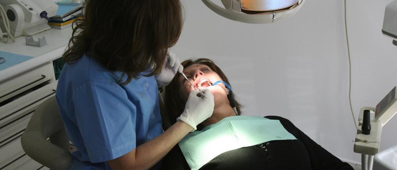 Una dentista atiende a un paciente.