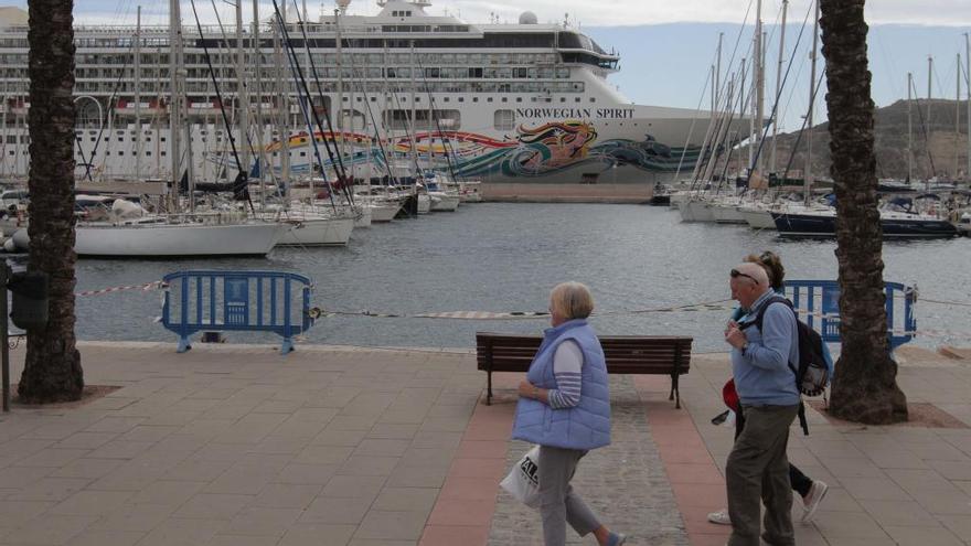 Varios turistas pasean por el paseo del Puerto de Cartagena frente a un crucero