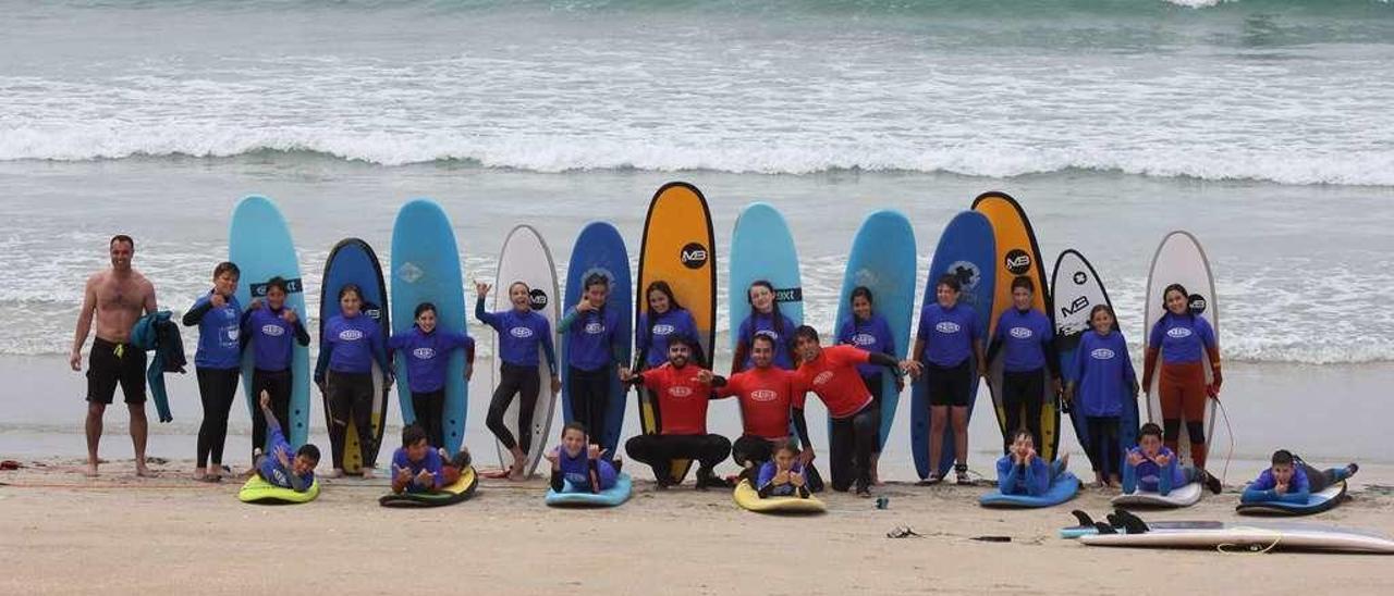 Alumnos y monitores de la Waipia Surf &amp; Paddle Surf School en la playa grovense de A Lanzada. // Waipia