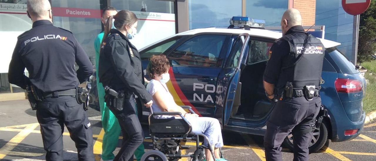 Agentes de la Policía Nacional custodian a la parricida, esposada, a su salida del Hospital de Jove, ayer. | M. C.