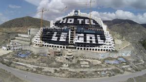 GRA216. CARBONERAS (ALMERÍA), 15/05/2014.- Una gran pintada en blanco con la leyenda Hotel sí cien por cien legal, Trabajo sí paro no sobre el fondo negro que a su vez pintaron los miembros de Greenpeace solicitando su derribo, así aparece el hotel de El Algarrobico en el municipio de Carboneras (Almería), tras haber realizado los vecinos unas pintadas esta mañana con las que reclaman su puesta en funcionamiento. EFE/Carlos Barba