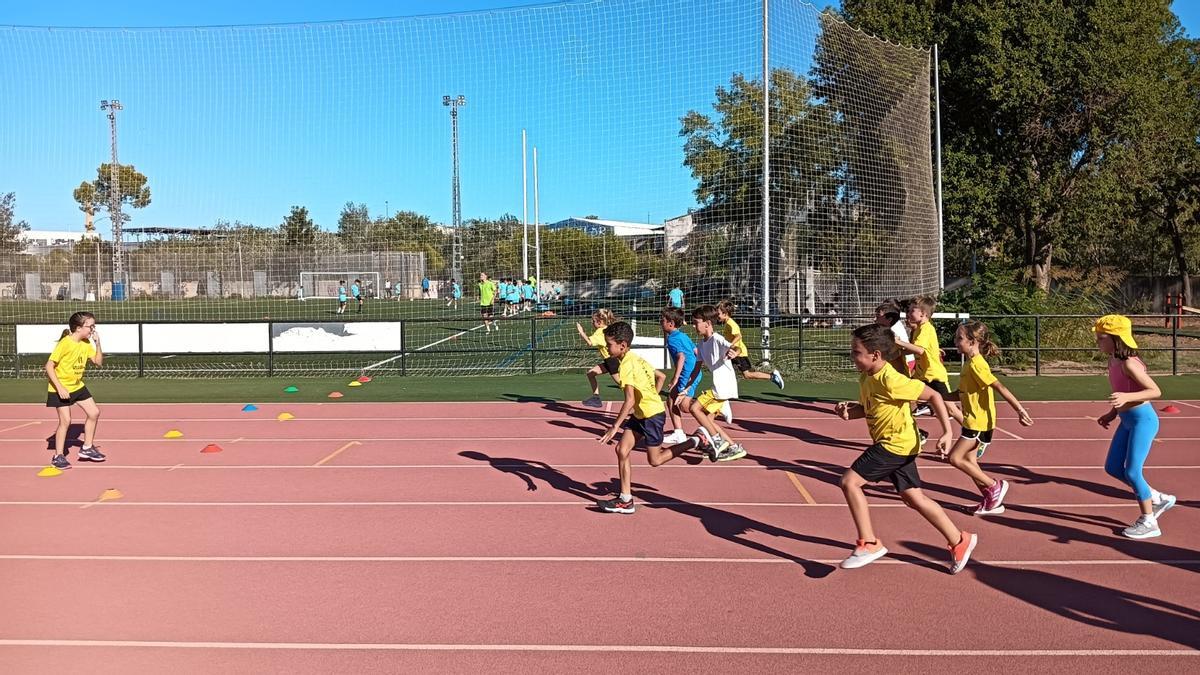 Niños y niñas de la escuela del CA Safor Teika se ejercita ellunes en la pista de atletismo de Gandia