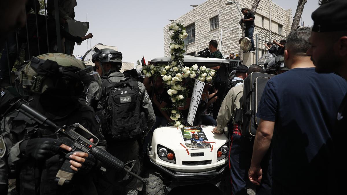 Soldados israelís vigilan de cerca el funeral por la periodista palestina muerta por fuego israelí en Jerusalén.