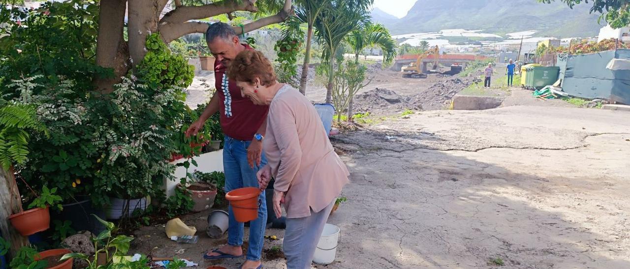 Marina Santana y Román Ojeda, ayer, cuidando de las flores en la vivienda familiar junto al barranco de Tocodomán, en obras.