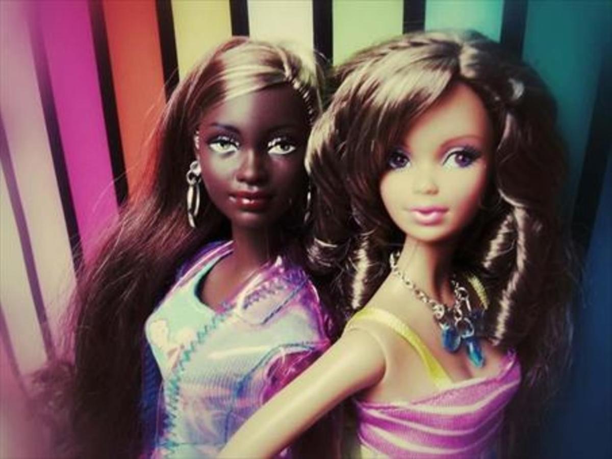 Una muñeca Barbie blanca y otra negra.