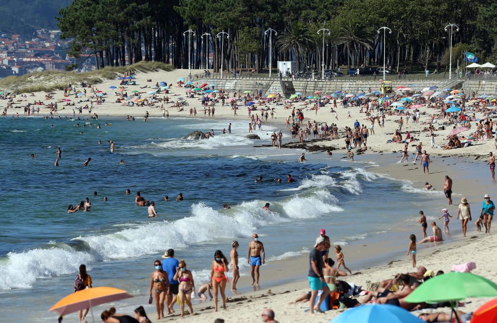 Bañistas disfrutando del buen tiempo en la playa de Samil. // Marta G. Brea